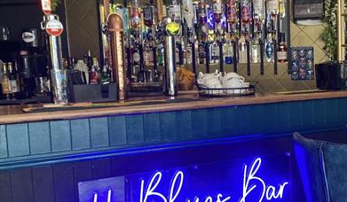 Photograph of the Blues Bar bar with electric blue signage
