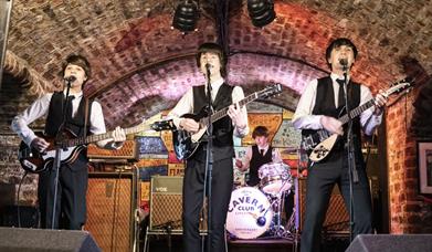 tribute band on stage, singing into mics