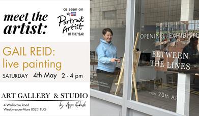 Photograph of artist Gail Reid painting in a window of a gallery.
