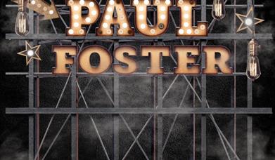Photograph of Paul Foster's name in lights on a stage.