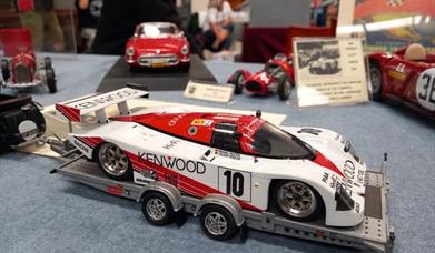 A picture of a red and white model racing car on a model trailer to advertise a model show at the Weston-super-Mare Helicopter Museum