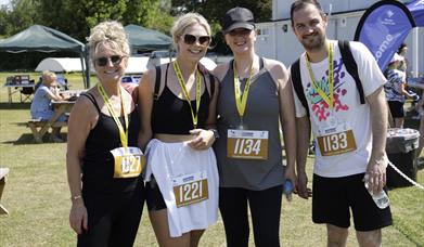 Mendip Challenge participants with their medals and walking numbers stood at Weston Cricket Club.