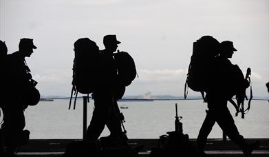 Silhouette showing military servicemen with their backpacks