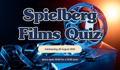 rectangular image with a film reel as the background layer. layered on top is the name of the event in dark blue writing with a cream border around ea