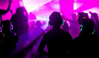 People wearing headphones and dancing at a silent disco