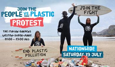 A pile of litter on a beach with three people wearing wetsuits behind it.  The lady on the left kneeling and holding a surfboard in front of her with