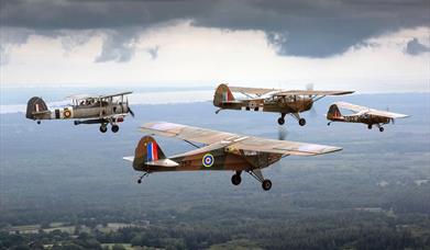 Four vintage military aeroplanes flying in formation