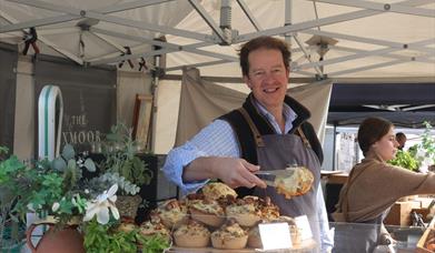 A stall holder serving a customer at the Eat;Weston Food Festival