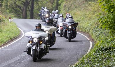 A procession of Harley Davidson motorbike riders driving into Weston-super-Mare from Sand Bay