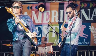 Lipinski Bros playing guitars on stage.