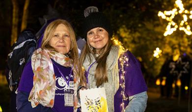 Moonlight Memory Walkers poster - two ladies wearing lights and memory walk t-shirts.