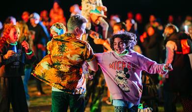 A male and female dancing in the crowd at the Mendip Family Festival