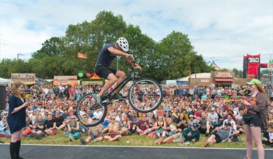 A mountain bike stunt rider jumping over a tightrope