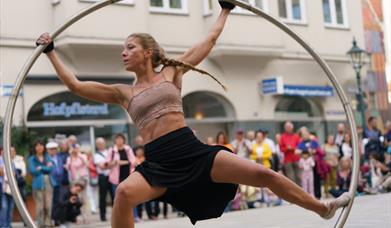 A woman balanced on a large hoop