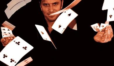 Poster of Richard Griffin, Magician, against a black backdrop and cards flying through the air.