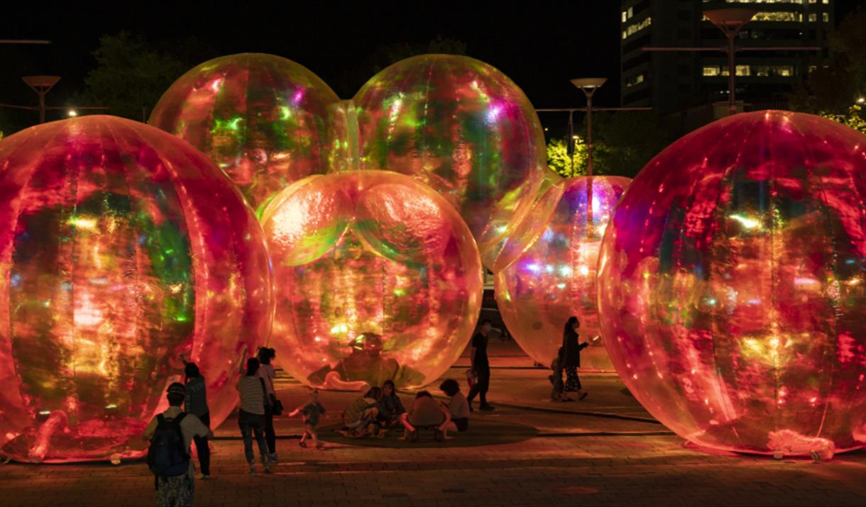 People stood next to lit up inflatable balls