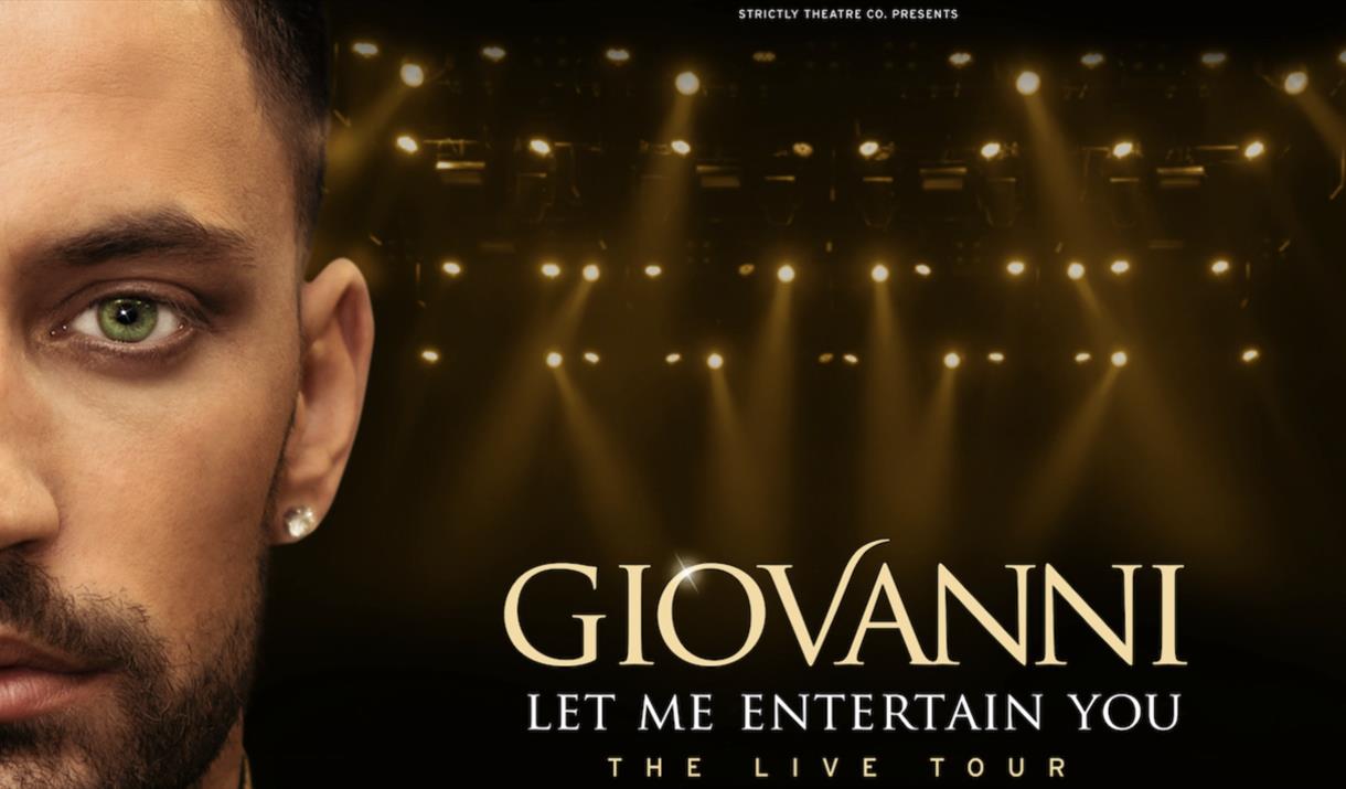 Gionvanni facing the camera with spotlights behind hm.