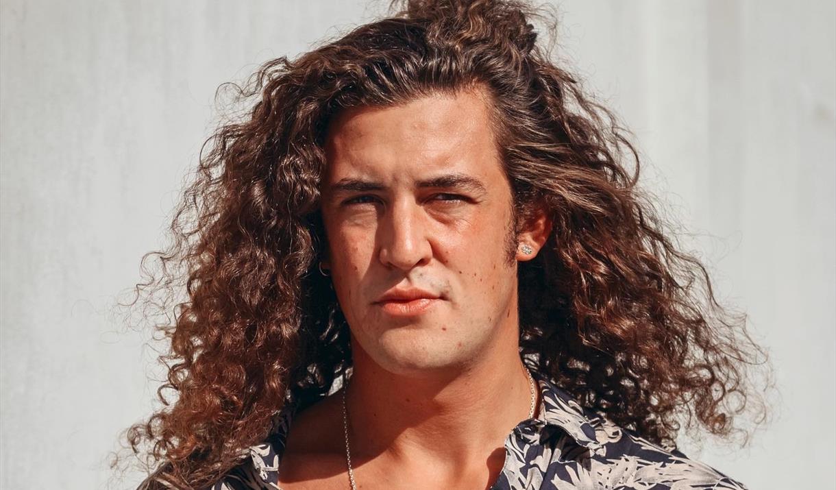 Portrait of singer songwriter Harrisen Larner-Main with his long curly hair and open necked shirt
