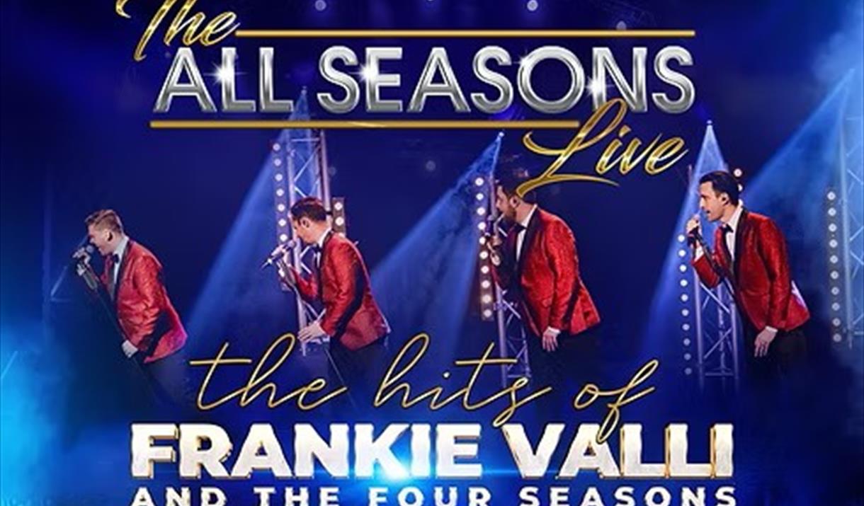 Four performers from the group All Season on stage singing and wearing red jackets