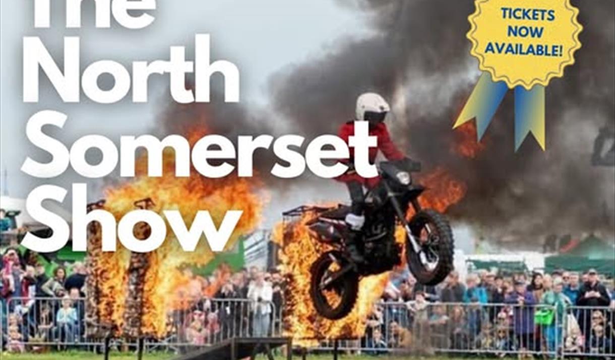 A motorbike stunt rider riding through a flaming arch on a poster advertising the North Somerset Show