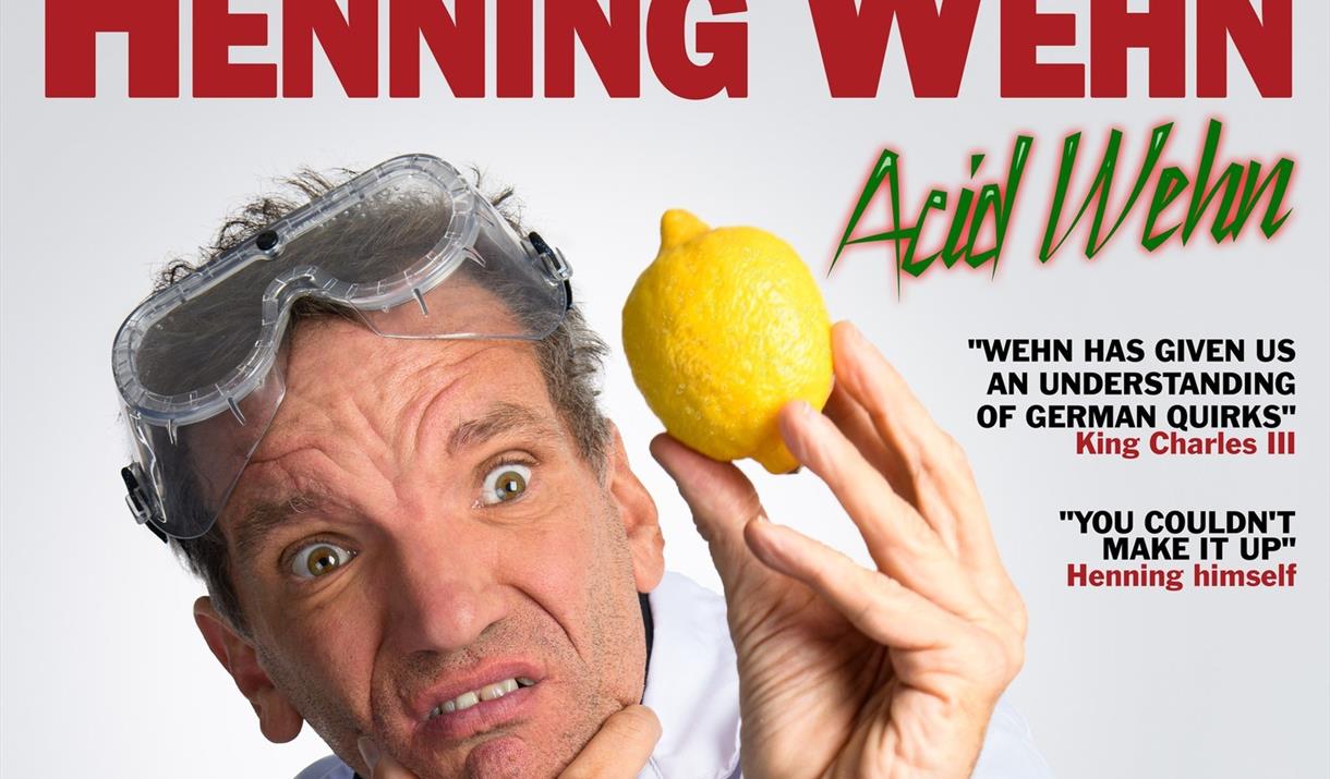 Comedian Henning Wehh holding his chin in one hand and a lemon in the other