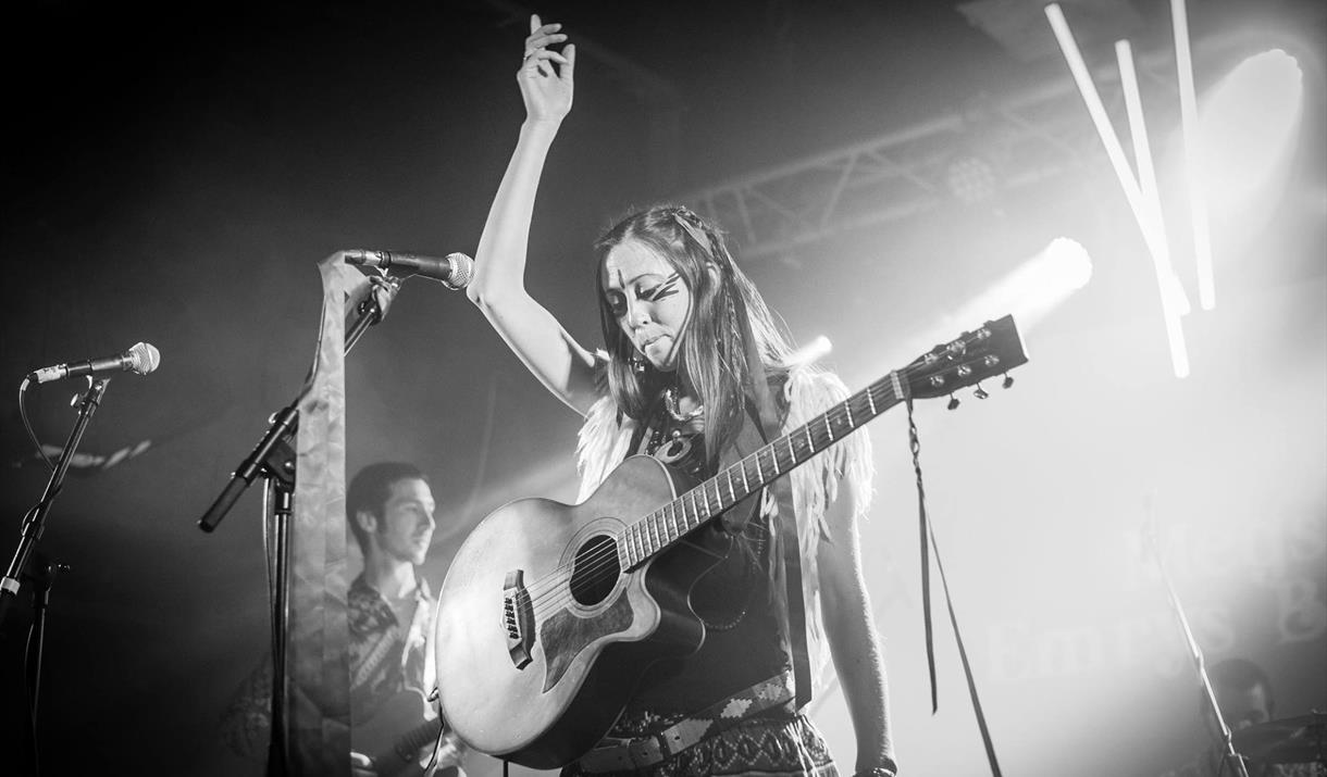 Black and white picture of the artist with guitar