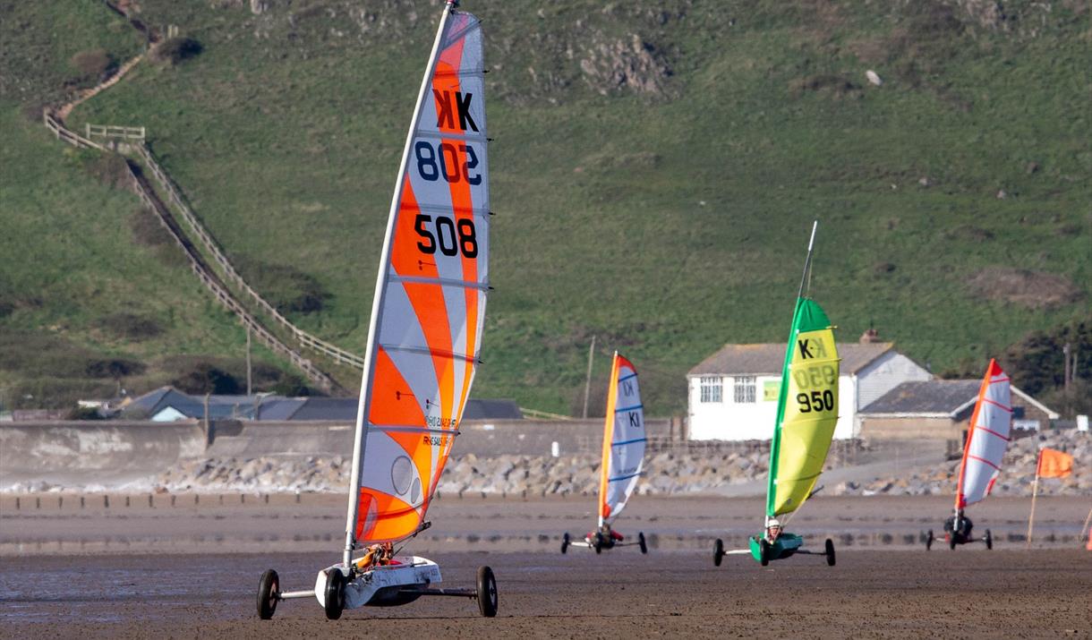 Four land yachts racing cross the sand at Brean Beach