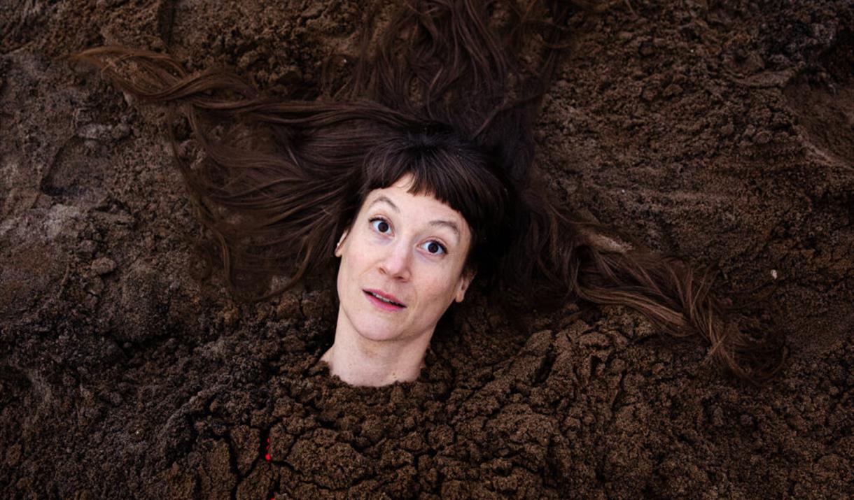 A person's head. Their body has been buried in soil