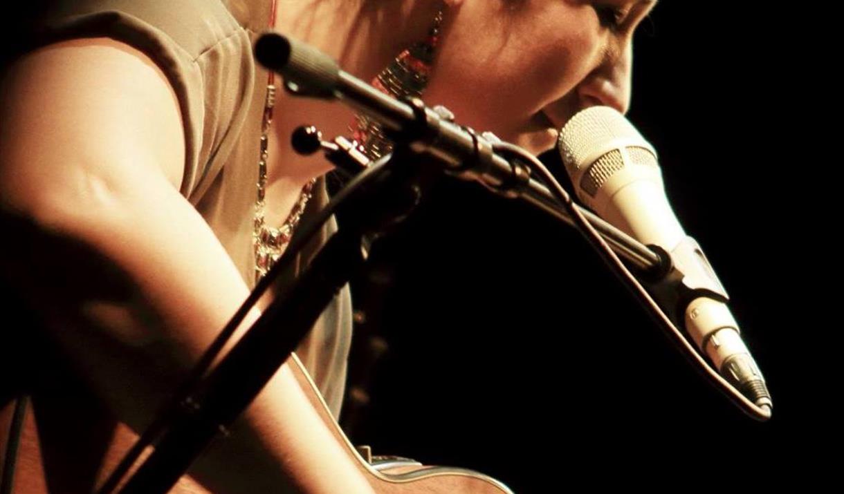 Woman looking at guitar, playing