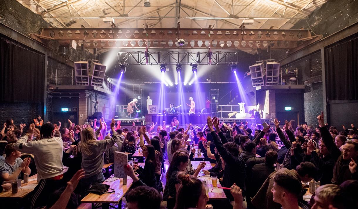 A crowd of bingo lingo partygoers standing up and partying at their tables