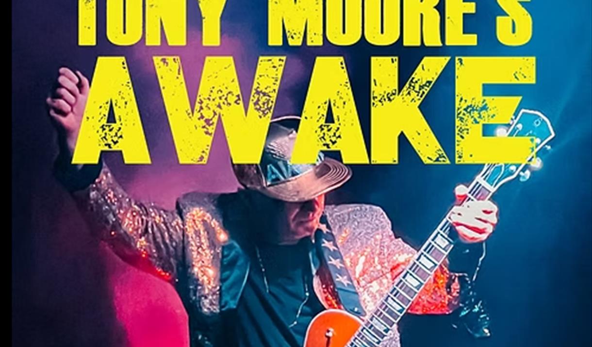 Guitarist Tony Moore playing on stage with the words Tony Moore's Awake superimposed