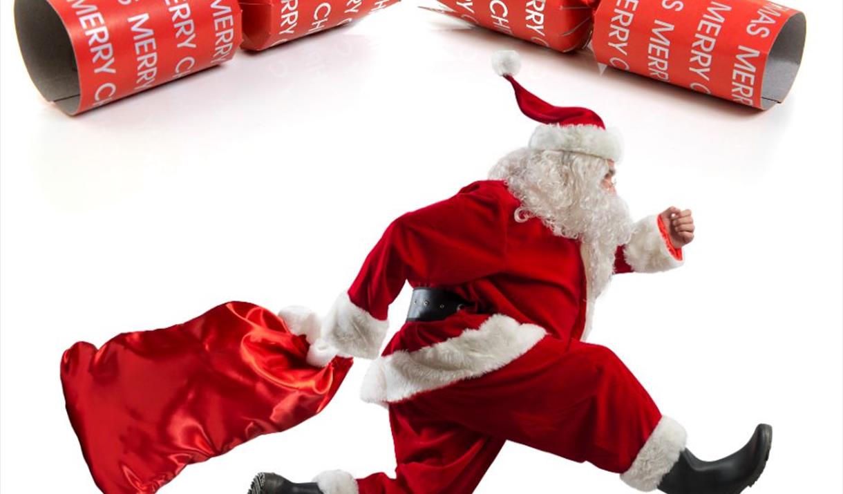 Santa Claus with a red sack running beneath a Christmas cracker