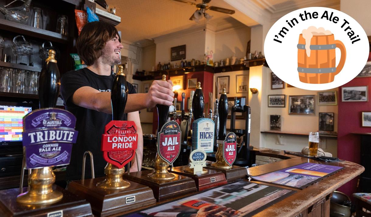 A barman pulling a pint in a pub over-stamped with an I'm in the ale trail logo