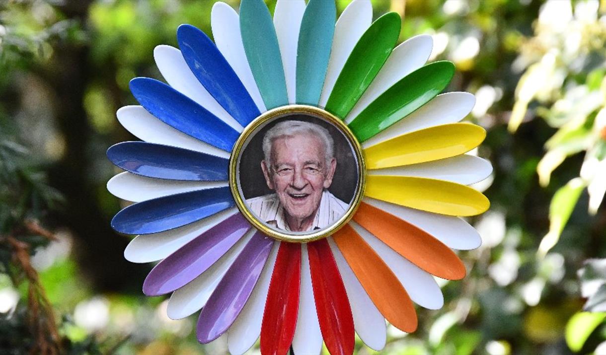 Man with his head on the face of a giant daisy flower