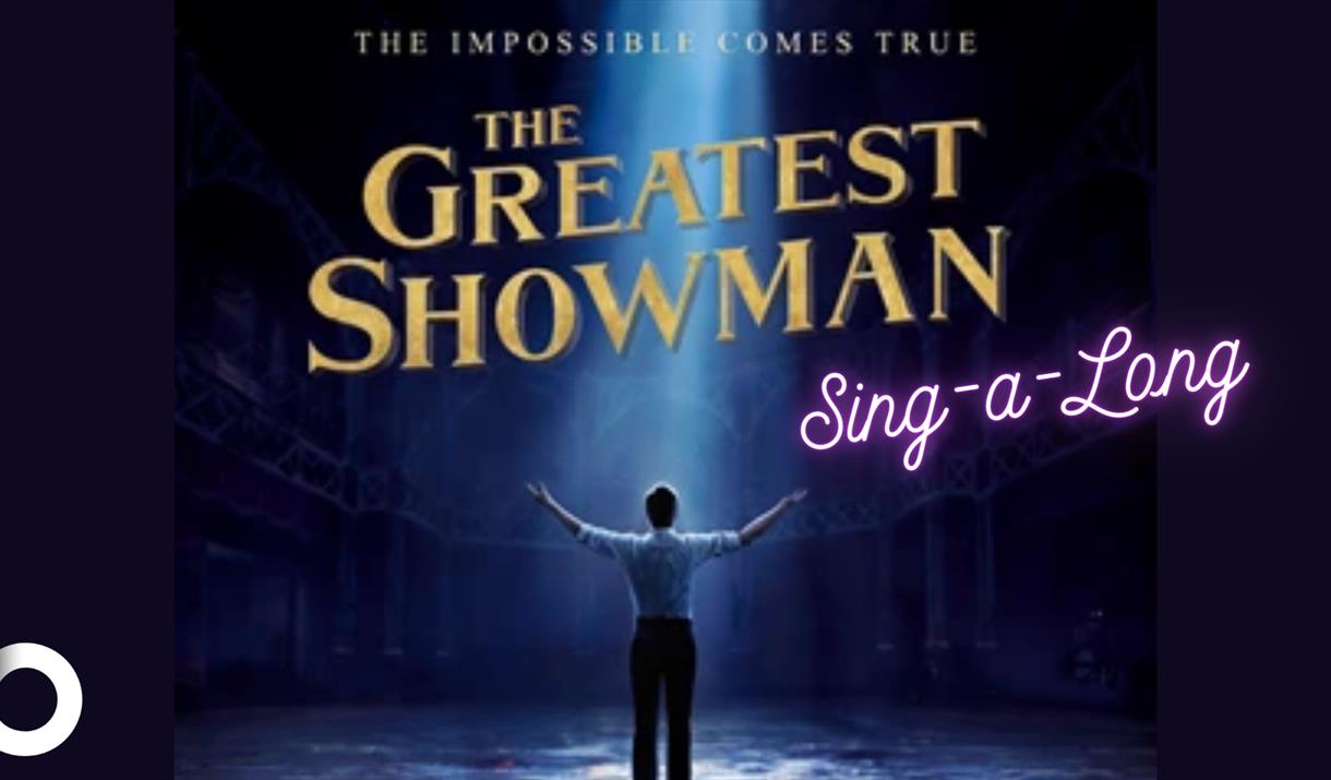 The Greatest Showman Sing-a-Long poster with an individual standing underneath a spotlight.