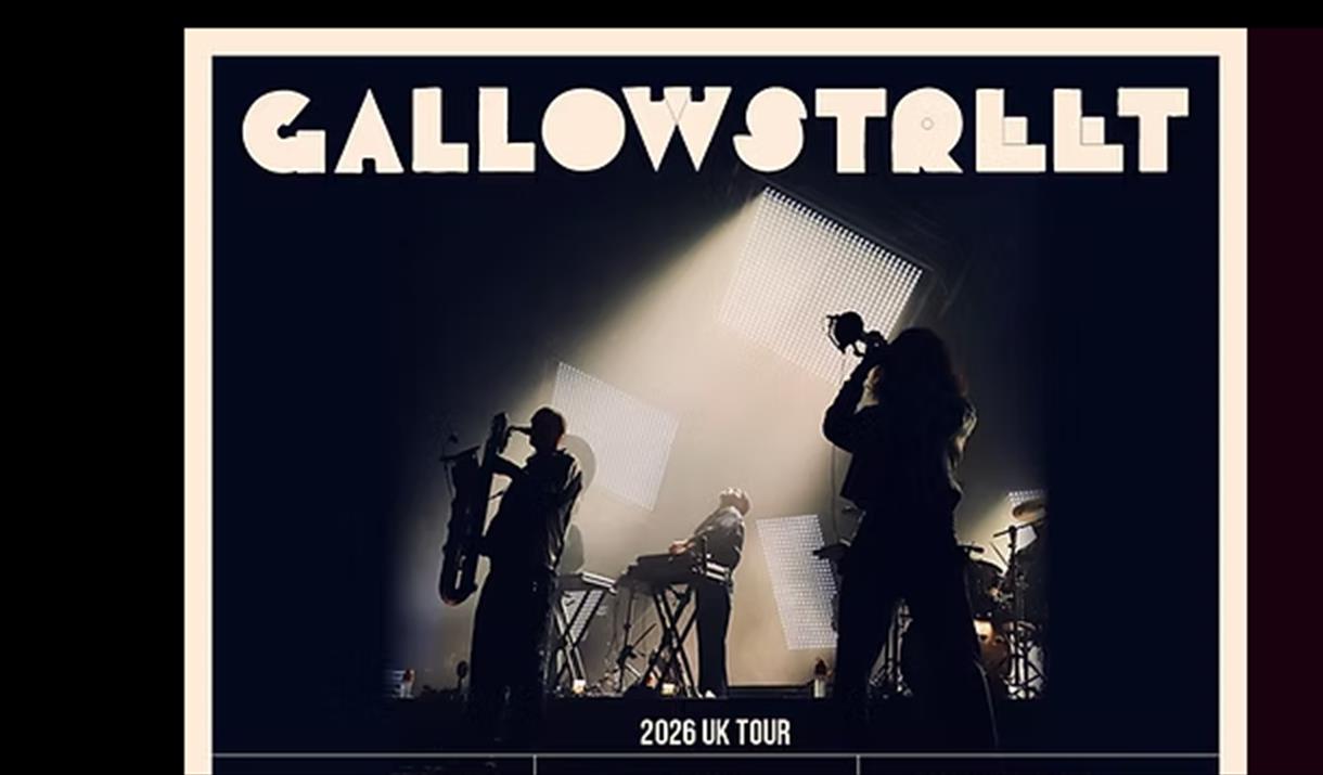 Silhouette of three members of a brass band on stage in a black and white image