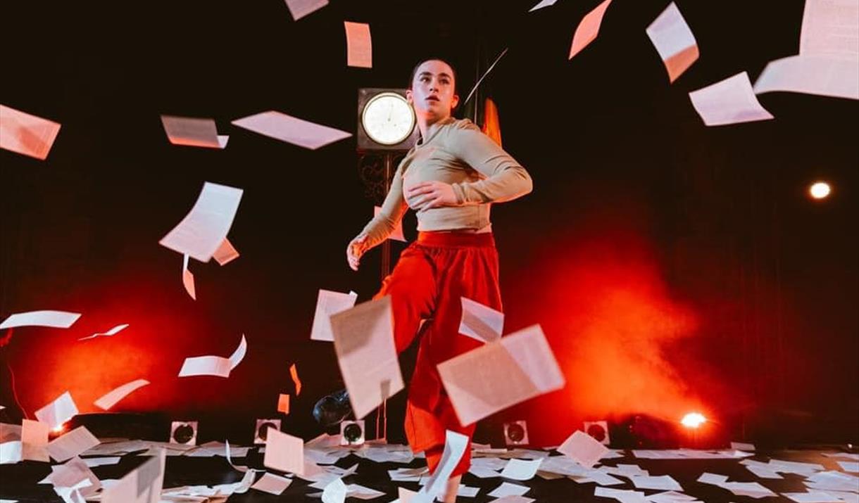 person moving through flying sheets of paper