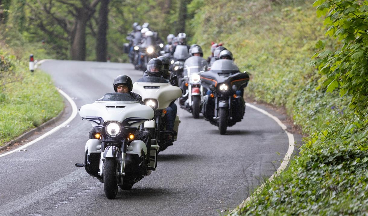 A procession of Harley Davidson motorbike riders driving into Weston-super-Mare from Sand Bay