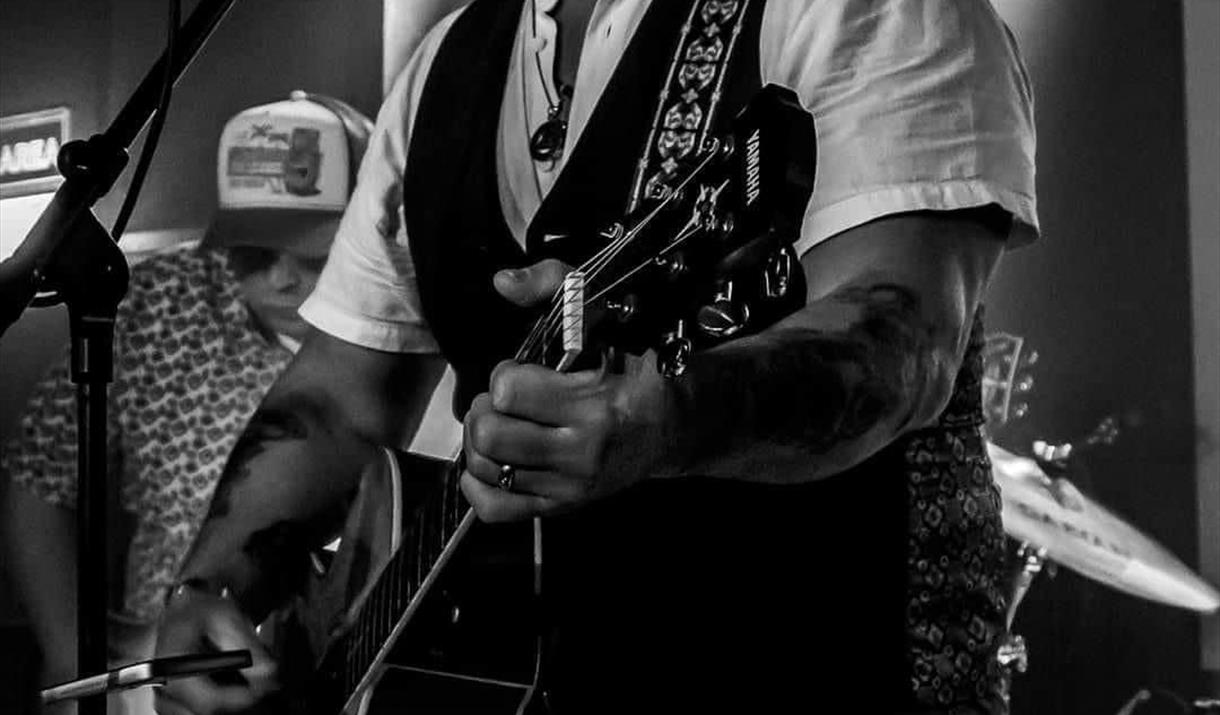 Black and white photograph of Steve Mitchell playing the guitar