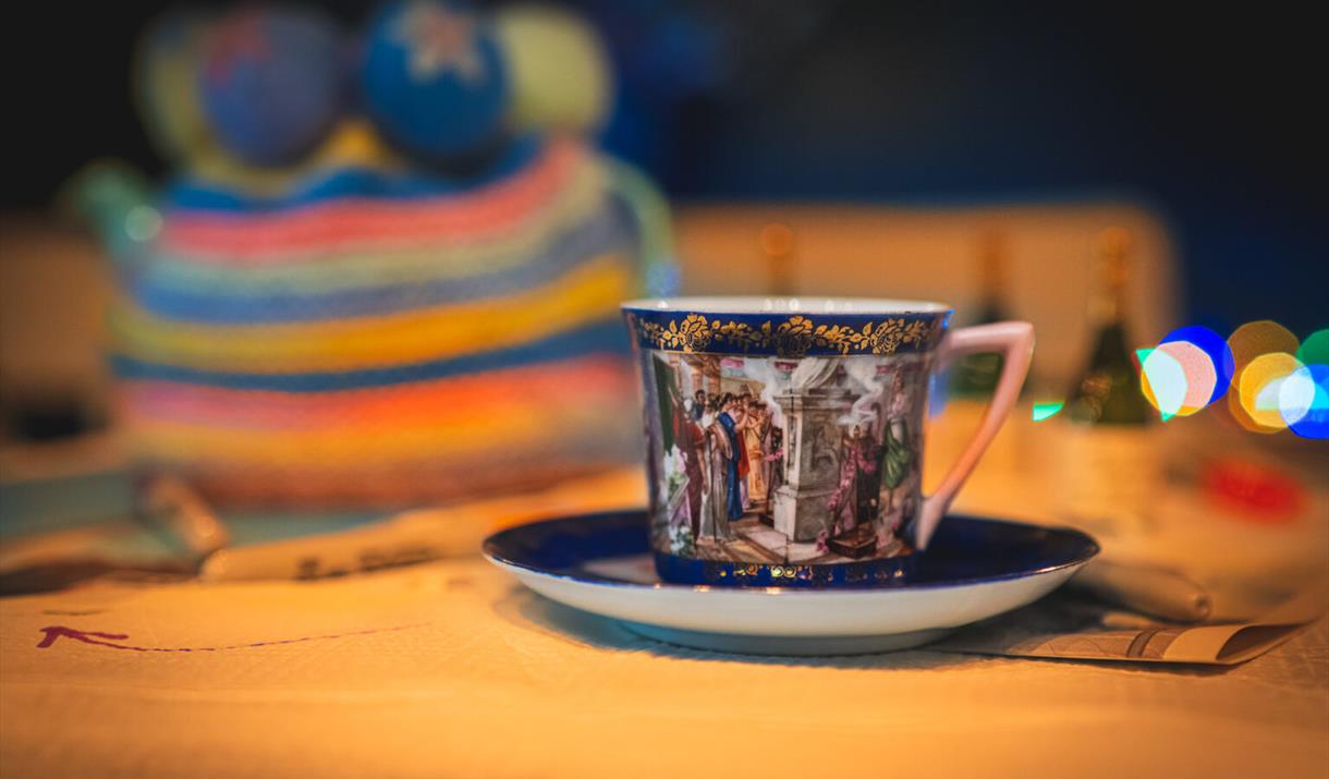 Photograph of a china cup and saucer in dark blue.