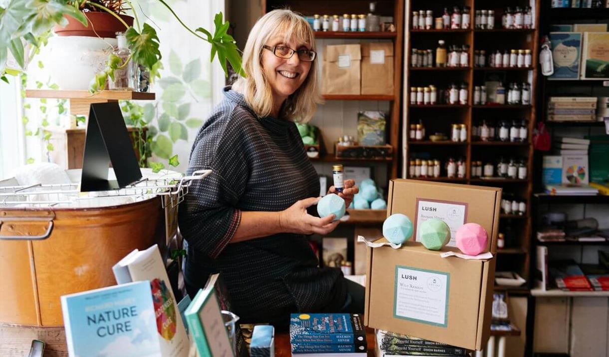 Photograph of Poet, Deb Alma, sat in a book shop.
