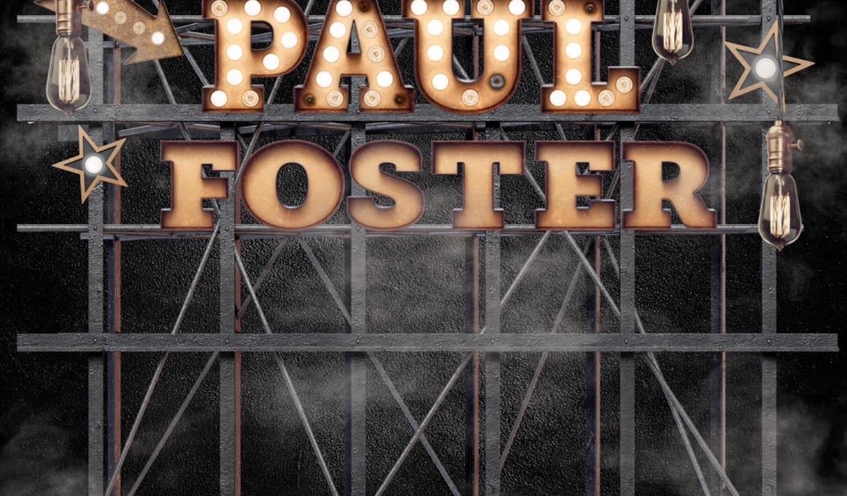 Photograph of Paul Foster's name in lights on a stage.