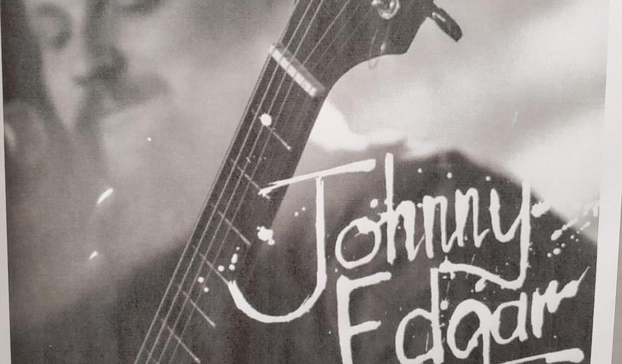 Black and white photo of JE playing guitar