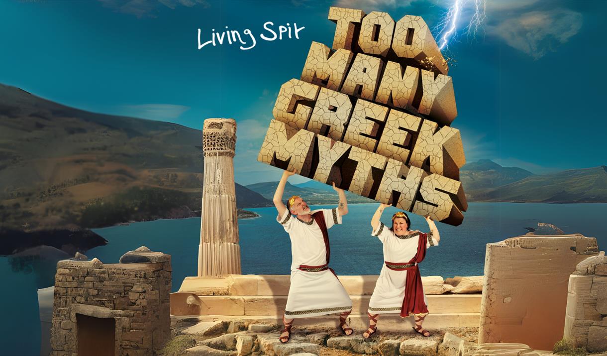 Cartoon style image featuring two men in white togas lifting up stone blocks spelling out the words Too Many Greek Myths while standing on top of an a
