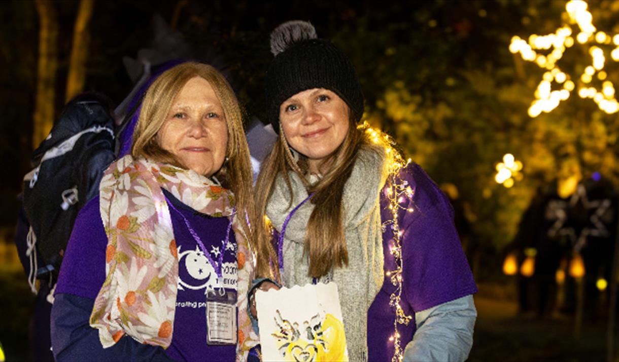 Moonlight Memory Walkers poster - two ladies wearing lights and memory walk t-shirts.