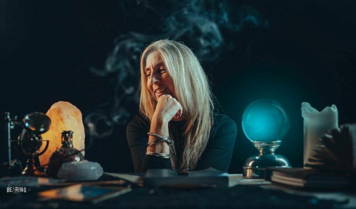 Photograph of Melanie sitting at desk with crystals.