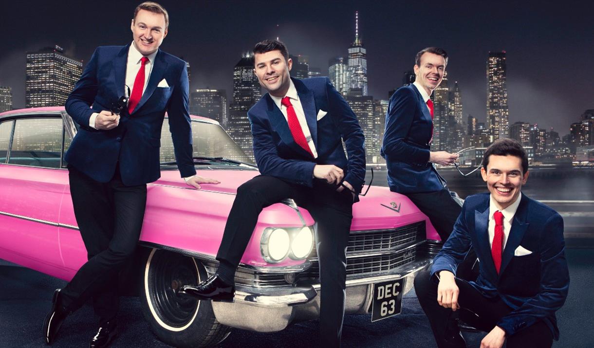 Frankie Valli and band sitting on a pink Cadillac