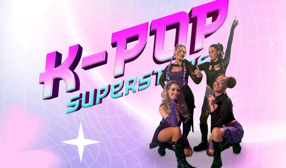Four female dancers on a purple poster advertising a K-Pop Superstars event at the Grand Pier
