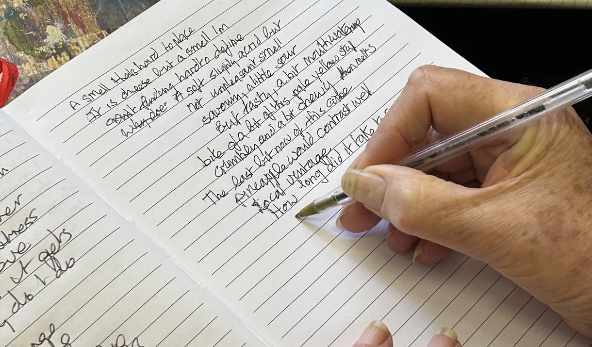 Hand holding pen writing on a notebook