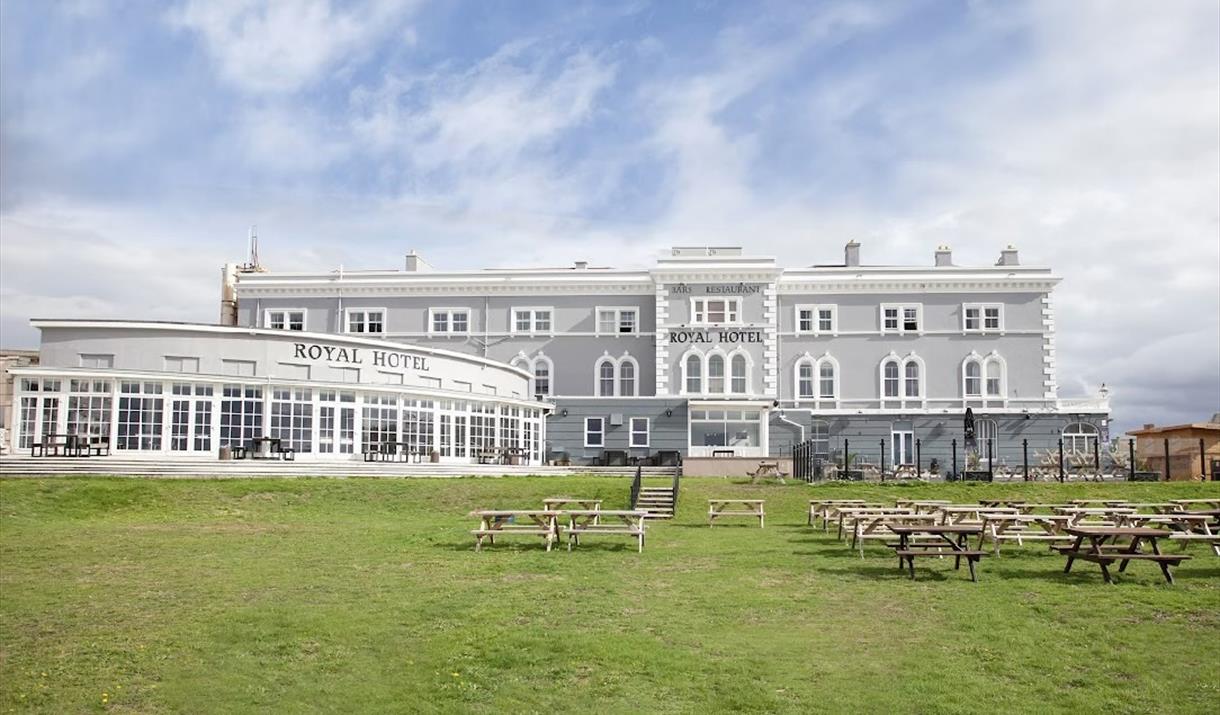 View to a palatial large hotel with a large lawn in the foreground